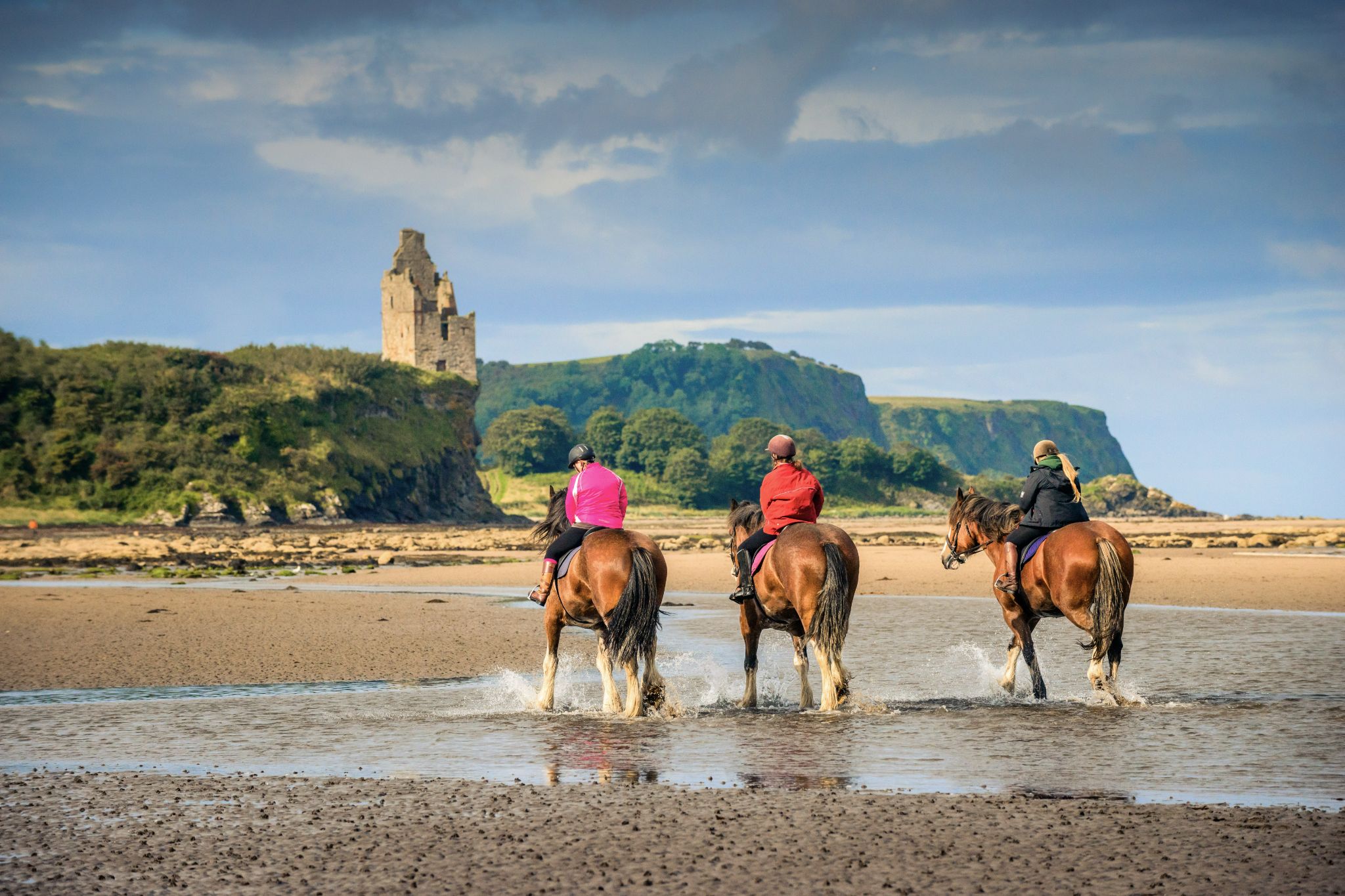 A horse rider gallops along Ayr Beach